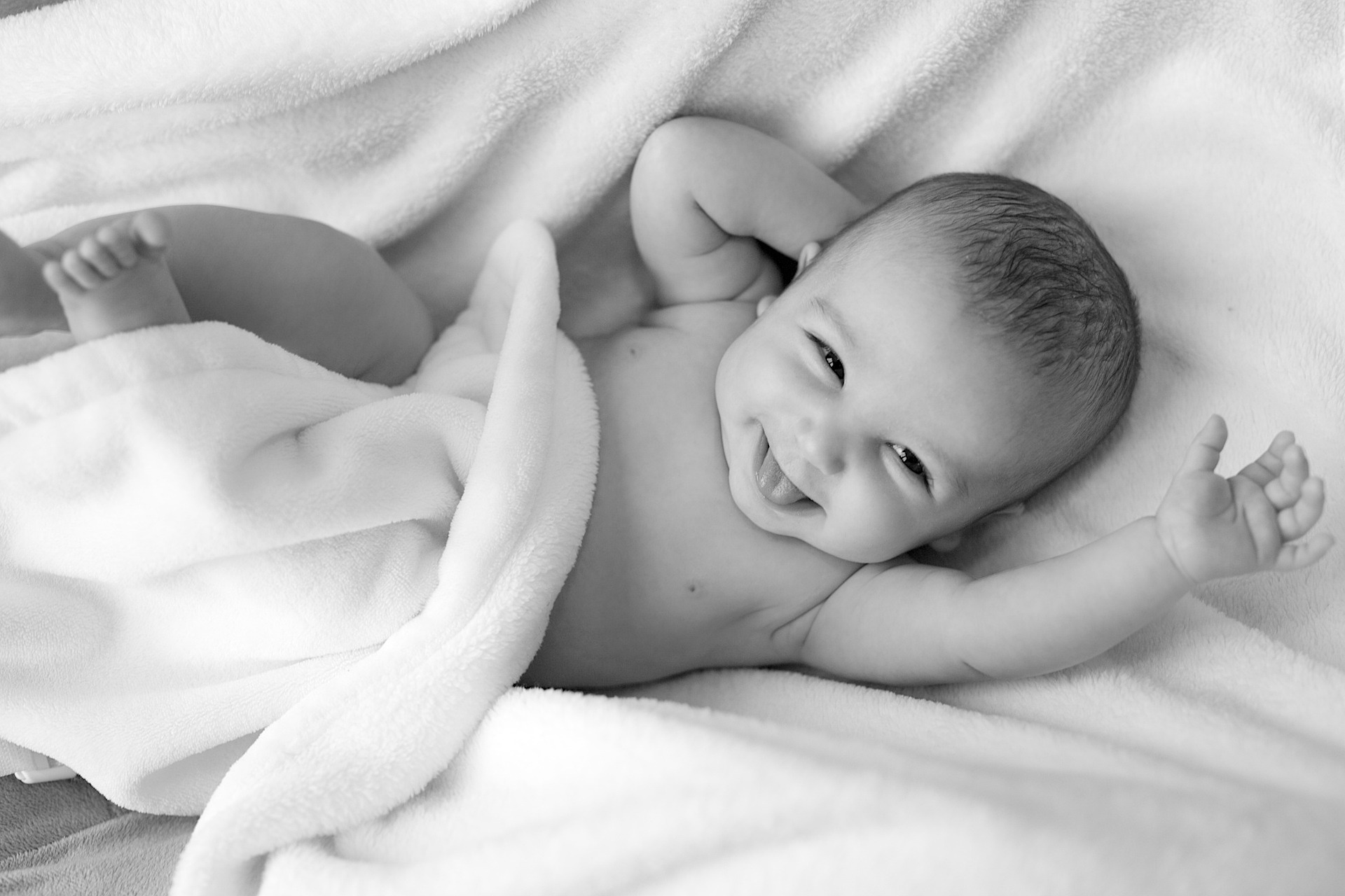 Bebé sonriendo tumbado en la cama